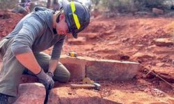 crew member does rock work on check steps